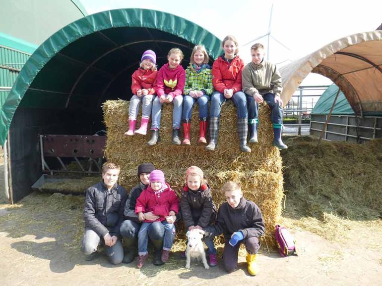 Sie sind bei uns gern gesehen Kindergruppe auf Strohballen